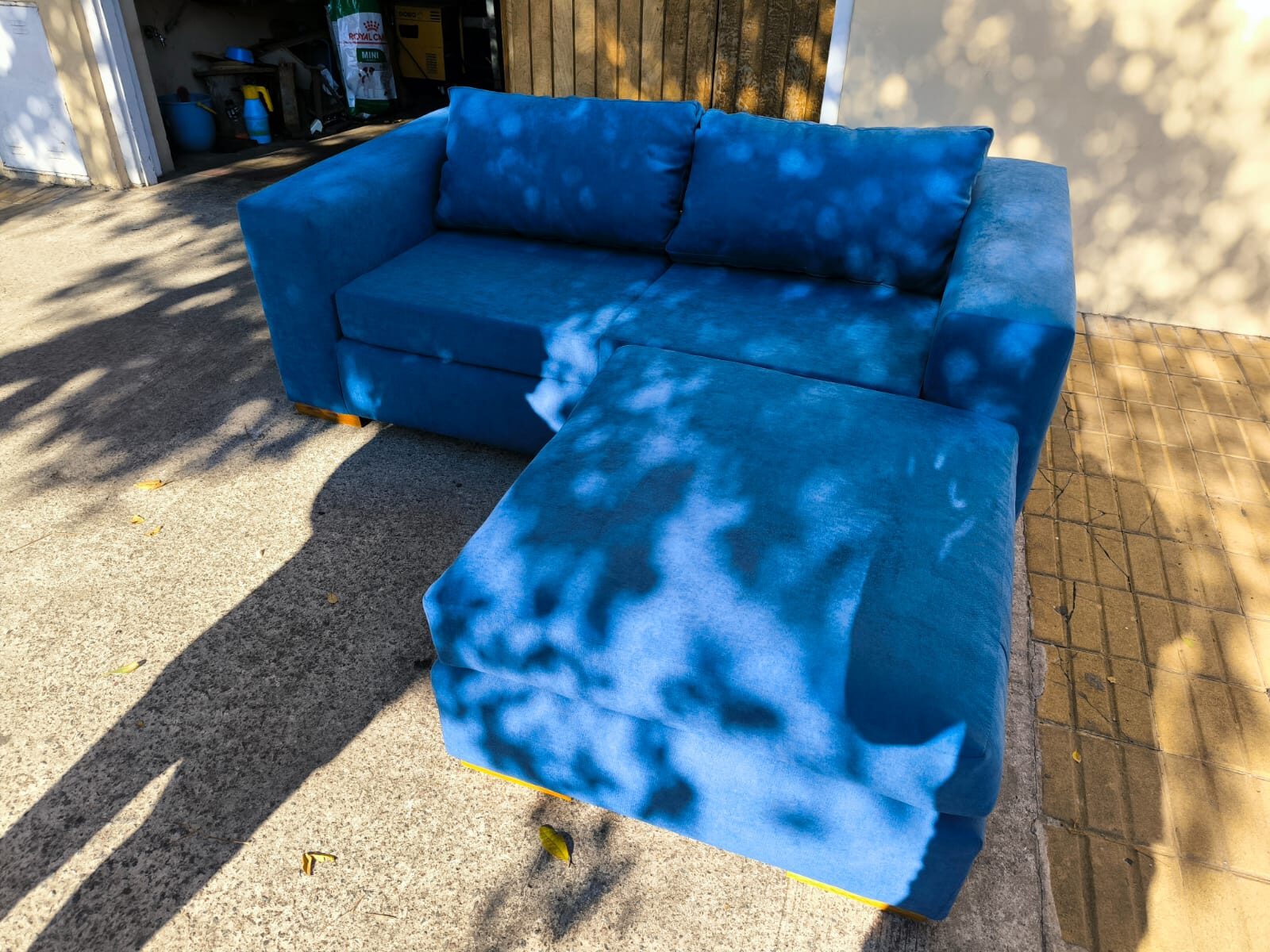 Sofá en terciopelo azul con puff
